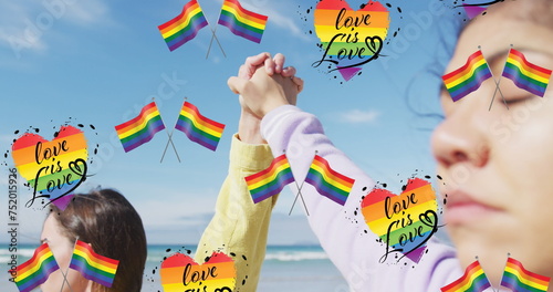 Image of rainbow flags, heart and love is love over lesbian couple holding hands outdoors