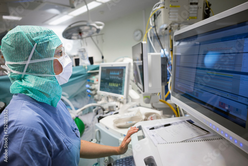 Female doctor examining medical reports on computer while working in hospital photo