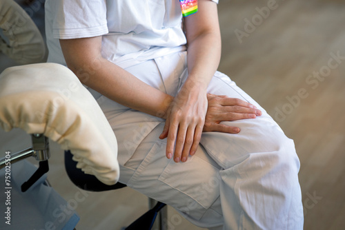 Midsection of female gynecologist sitting on chair in clinic photo