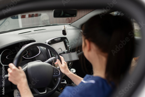 Female healthcare worker driving car while traveling to work photo