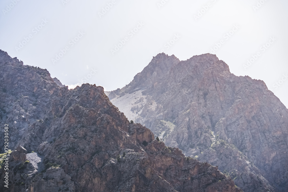 Fototapeta premium View of the mountain ranges and peaks of the Fan Mountains with glaciers, rocks and vegetation in Tajikistan, mountain panorama on a summer sunny day