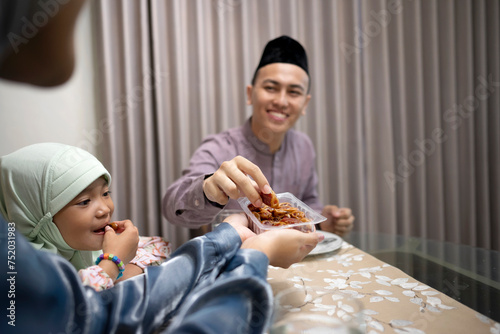 Indonesian muslim family eating kurma while breakfast in the dining room. photo