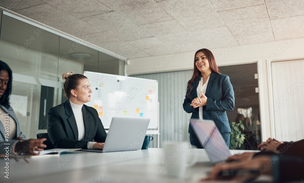 © Flamingo Images - Smiling businesswoman giving her team a whiteboard presentation in an office