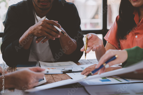 Financial analyst analyzes business finance reports on laptop and graph documents during corporate meeting discussions showing successful teamwork, business meeting ideas, marketing.