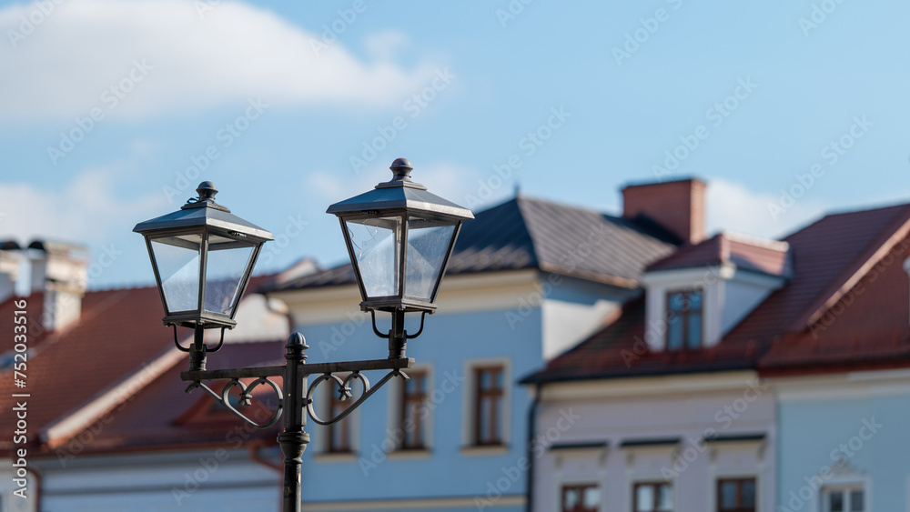 Urban street lamp in retro style against the background of blurred tenement houses