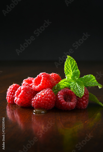 Fresh raspberries with mint on a dark background
