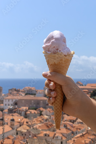 Hand  holding ice cream on the background of the city. Summer concept. Selective focus © NatalKa 