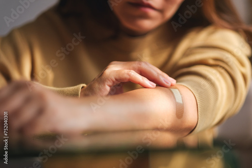 Closeup image of a woman with adhesive bandage  medical plaster  band aid on her arm