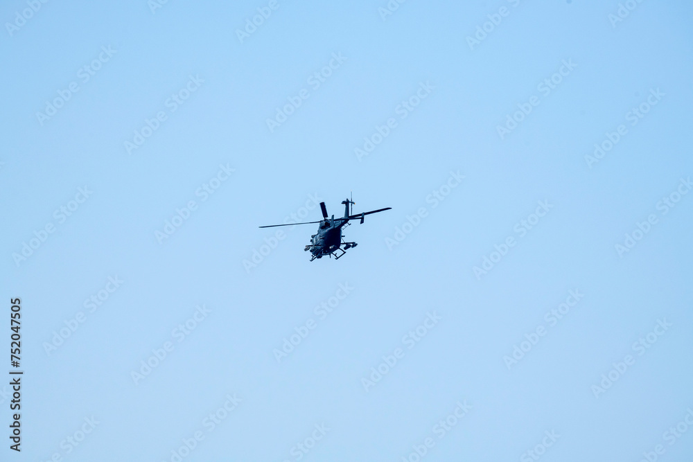 Combat helicopter is flying on isolated blue sky. Combat helicopter is flying on isolated blue sky.