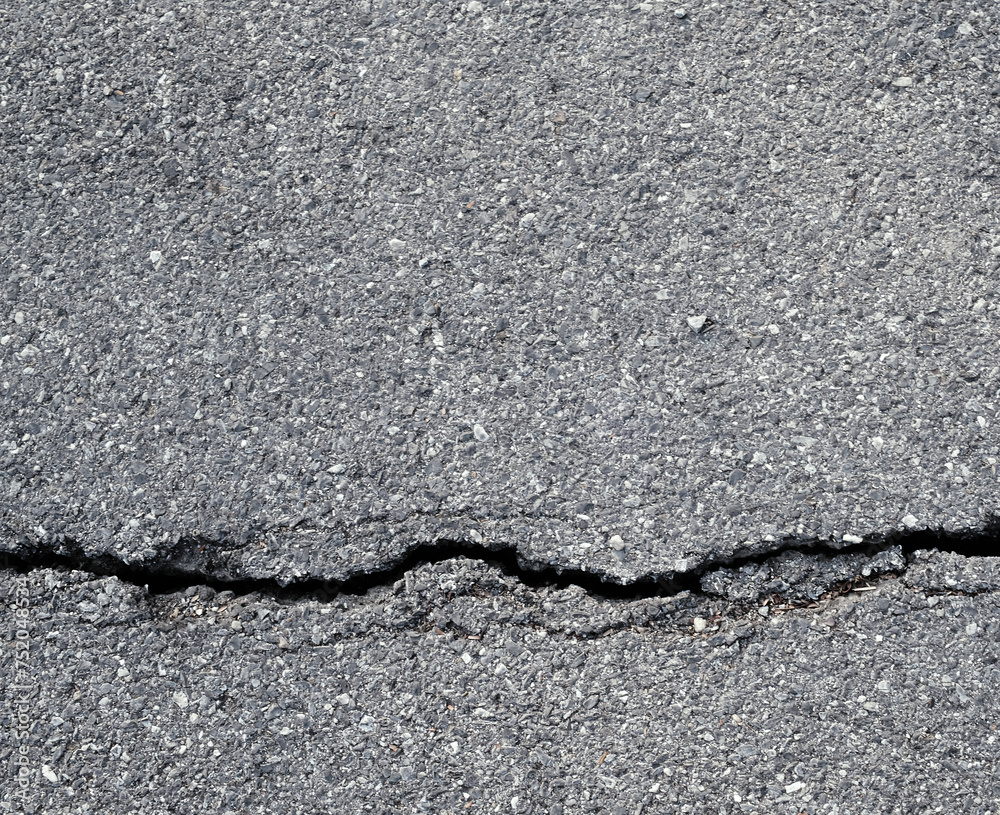 Obraz premium Earthquake disaster background. Cracks of road surface. Broken tarmac backdrop. Asphalt pavement damage.