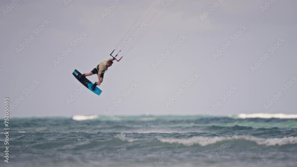 Medium panning shot of a kitebaorder jumping and doing tricks, slow motion Medium panning shot of a kitebaorder jumping and doing tricks, slow motion