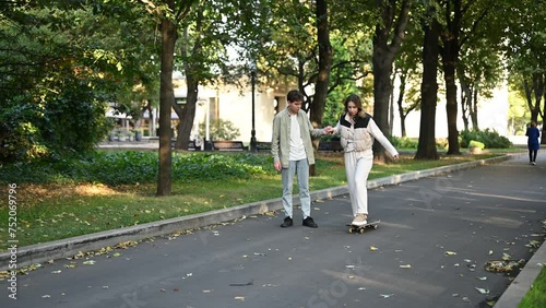 Wallpaper Mural Guy teaches girlfriend to skateboard in the park on a summer day Torontodigital.ca