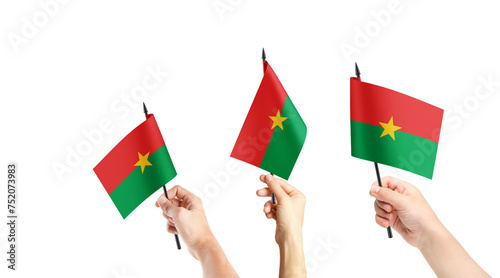 Fototapeta Naklejka Na Ścianę i Meble -  A group of people are holding small flags of Burkina Faso in their hands.
