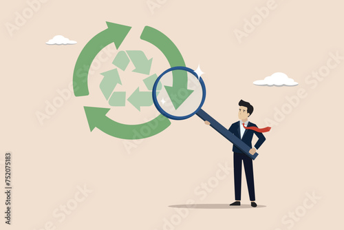 Circular economy, concept sustainability, energy or eco friendly product, recycle material or environment protection, businessman looking at the circular economy cycle using a magnifying glass.