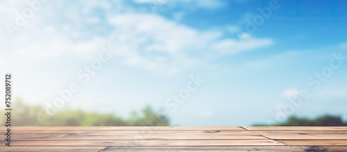 Serene Wood Tabletop with Ethereal Blue Sky Blur and Nature Reflection photo
