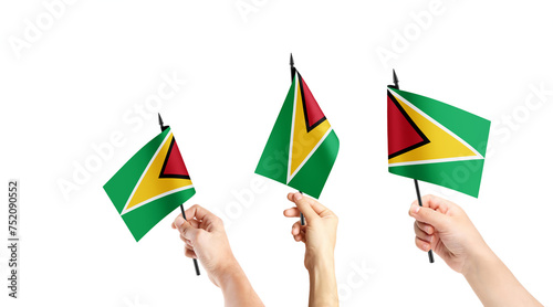 Fototapeta Naklejka Na Ścianę i Meble -  A group of people are holding small flags of Guyana in their hands.