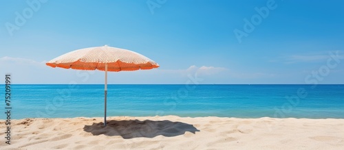 Serenity at Shore: A Beach Umbrella Brings Calm to a Sun-Kissed Sandy Beach © vxnaghiyev
