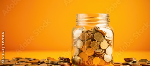 Fundraising and Charity Savings: Jar Packed with Coins on Vibrant Table Background photo
