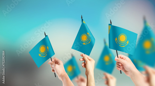 A group of people are holding small flags of Kazakhstan in their hands.
