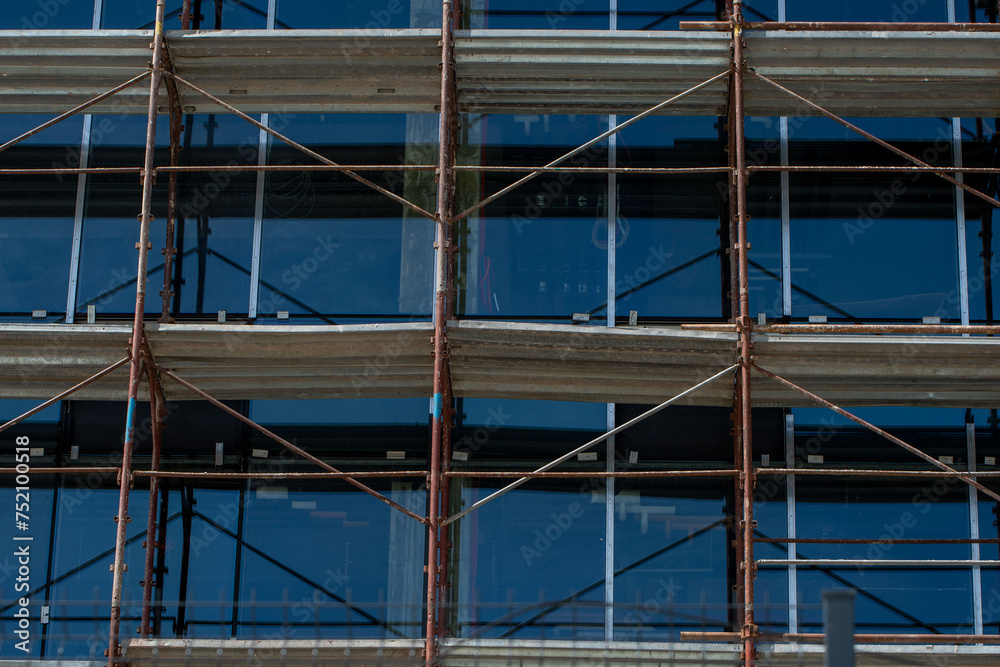 Modern Building Under Construction. Scaffolding, Glass Facade, Exterior Design.