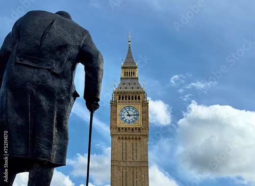 Rear view of the statue of Sir Winston Churchill overlooking Big Ben in Parliament Square, Westminster, London, UK. 