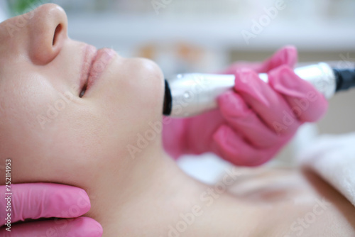 Close-up of Oxygen Mesotherapy Procedure on Facial Skin. A detailed close-up of a skincare professional performing oxygen mesotherapy on a female client's cheek in a beauty clinic