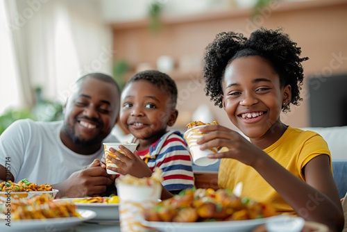 A diverse group of individuals happily seated around a table, indulging in a delicious meal together.