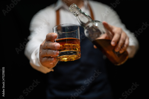 Bartender pours whiskey to customer in tavern