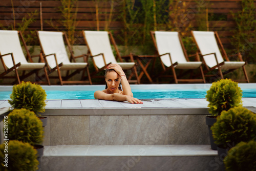 Beautiful young woman posing in swimming pool