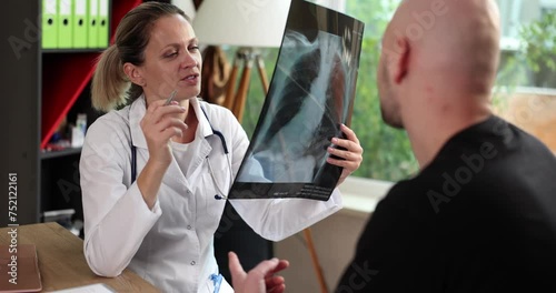 Female doctor in explaining diagnosis on x-ray lung fluorography to male patient during medical appointment in hospital. Pneumonia bronchitis asthma photo