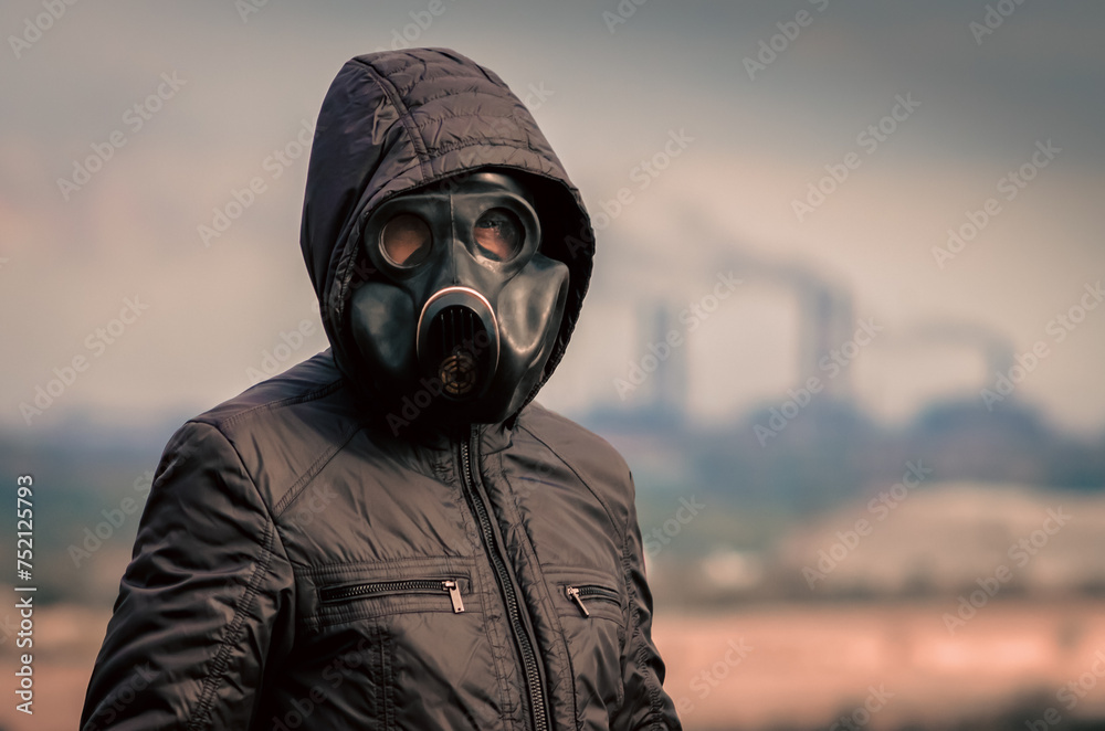 portrait of a man in a gas mask and a hood against the background of smoke from factory pipes portrait of a man in a gas mask and a hood against the background of smoke from factory pipes