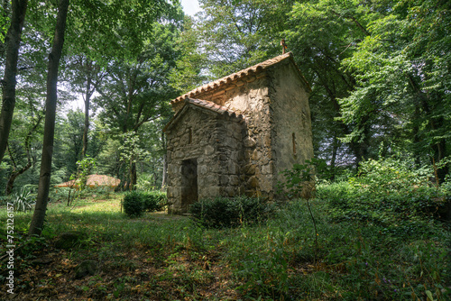 Church of St. Marine of Zegaani monastery. Surrounded by trees and bushes, standing on a green field. Illuminated by the sun's rays.