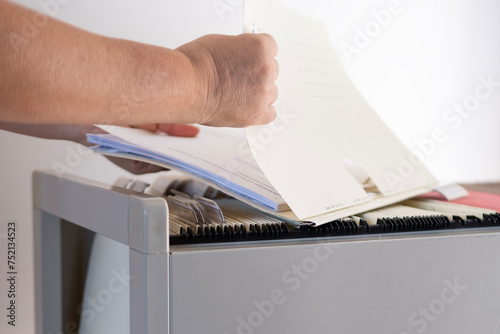 Foto female hands through folders In Document Storage close-up, Home Archive, Record