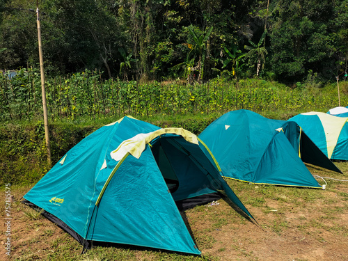 Beautiful view of camping tent at the foot of Mount Ungaran with blue sky blackground. Weekend camping trip. 