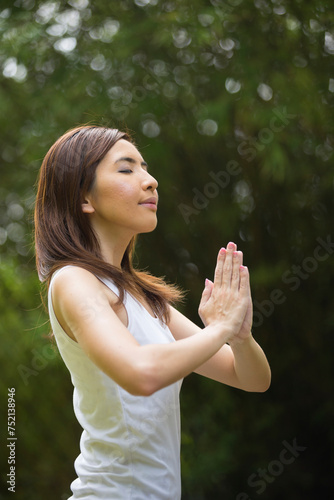 Chinese woman practicing yoga outdoors.