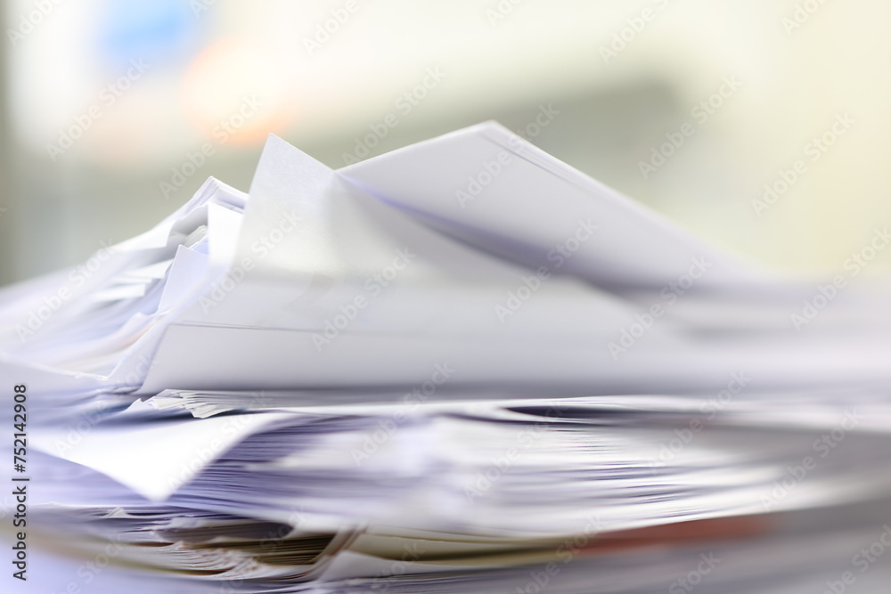 Close up of a stack of papers on a desk in the office.