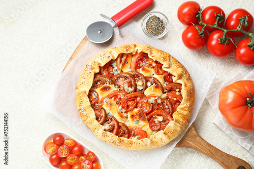 Flat lay composition of tasty galette with tomato and cheese (Caprese galette) on light textured table