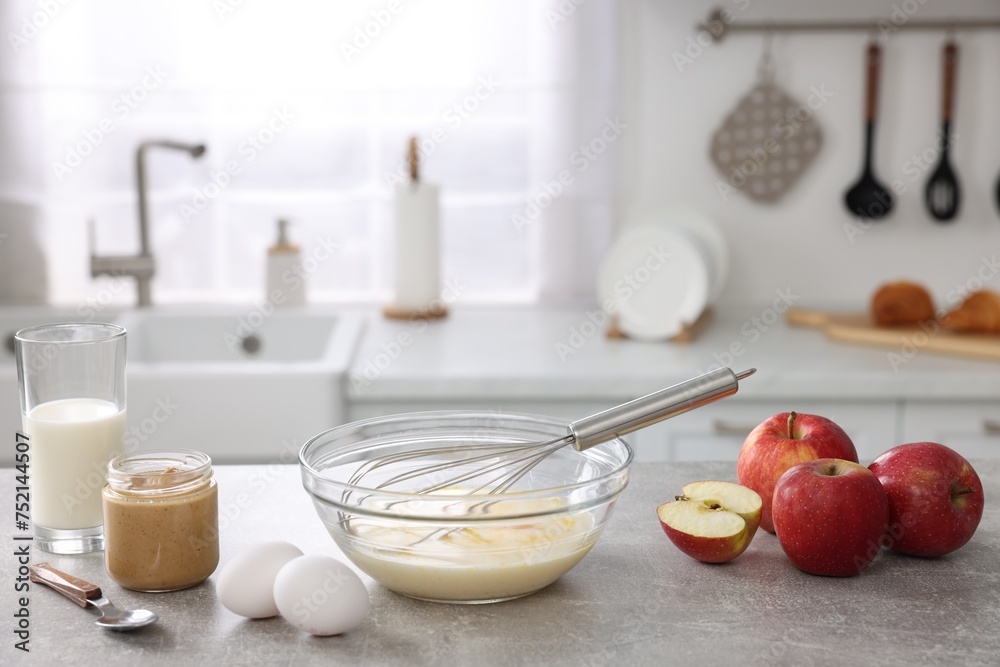 Whisk, bowl, beaten eggs and other ingredients on grey table indoors, space for text Whisk, bowl, beaten eggs and other ingredients on grey table indoors, space for text