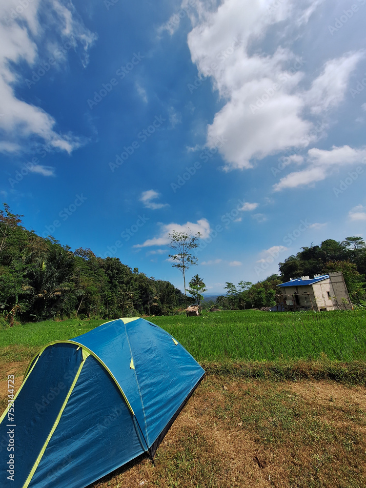 Beautiful view of camping tent at the foot of Mount Ungaran with blue sky blackground. Weekend camping trip.
