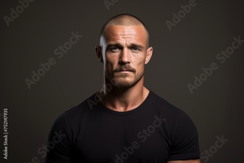 Portrait of a serious man in a black t-shirt on a dark background