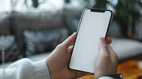 Man using smartphone blank screen frameless modern design while lying on the sofa in home interior