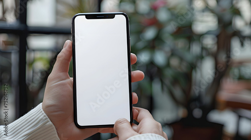 Man using smartphone blank screen frameless modern design while lying on the sofa in home interior