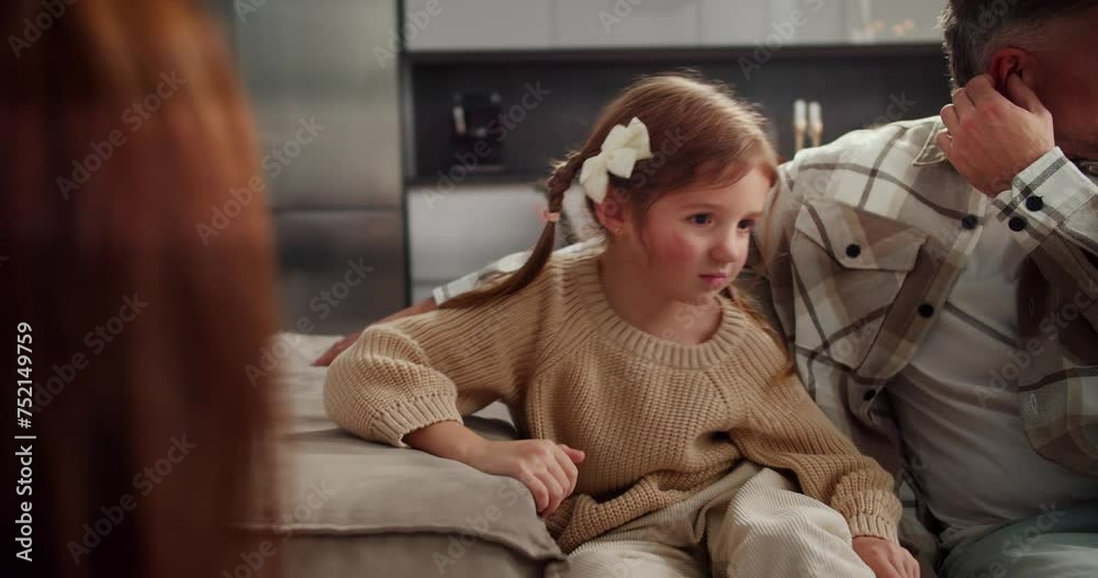 Sad angry little girl quarrels with her parents and is indignant about ...