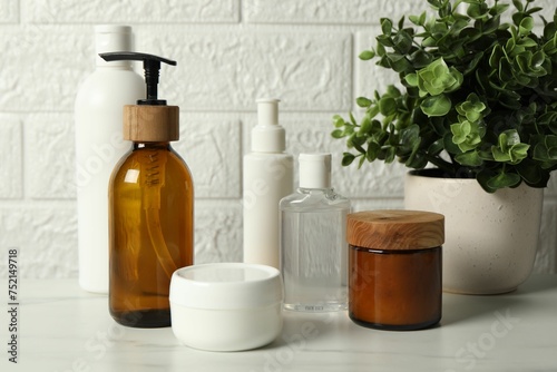 Bath accessories. Personal care products on white table near brick wall