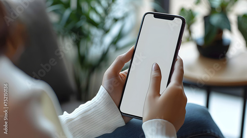 Man using smartphone blank screen frameless modern design while lying on the sofa in home interior