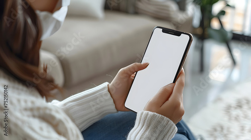 Man using smartphone blank screen frameless modern design while lying on the sofa in home interior