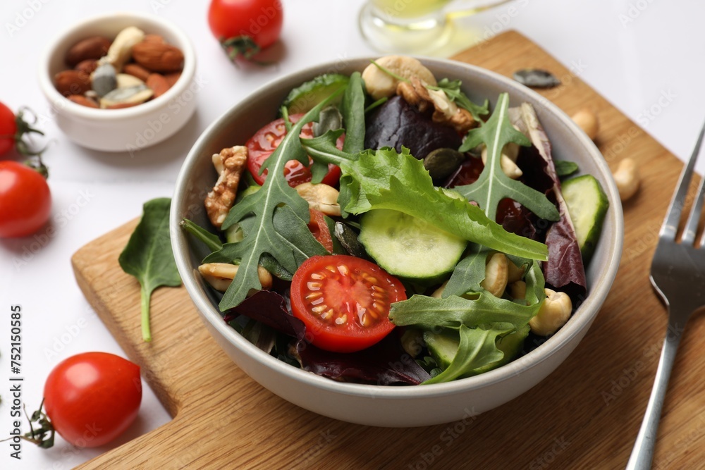 Tasty fresh vegetarian salad and ingredients on white table, closeup Tasty fresh vegetarian salad and ingredients on white table, closeup