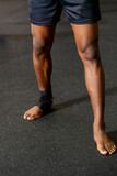 Powerful legs of a Black Muay Thai fighter, showcasing strength and determination. An inspiring image capturing the essence of discipline and resilience.