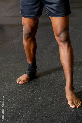 Powerful legs of a Black Muay Thai fighter, showcasing strength and determination. An inspiring image capturing the essence of discipline and resilience.