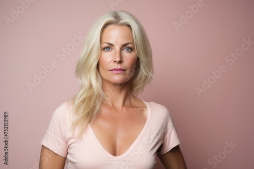Portrait of a beautiful blonde woman on a pink background looking at the camera